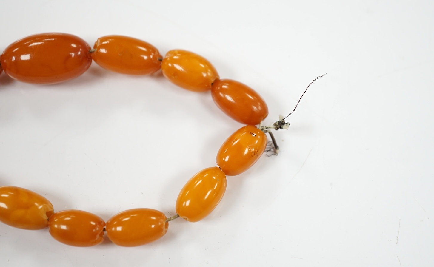 A single strand graduated amber bead necklace, 66cm, gross weight 40 grams. Condition - poor to fair